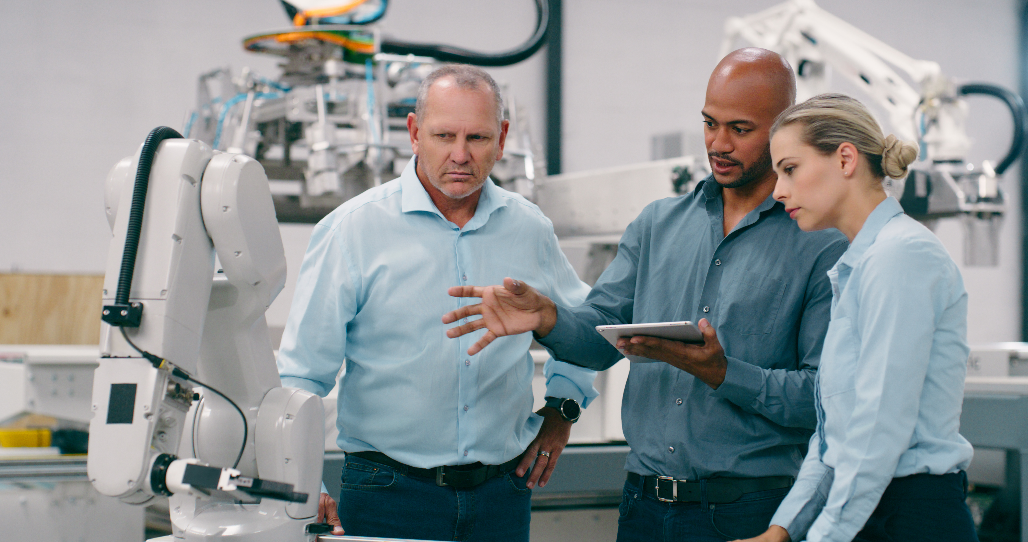 Industrial engineers training on a robotic system in a smart manufacturing facility